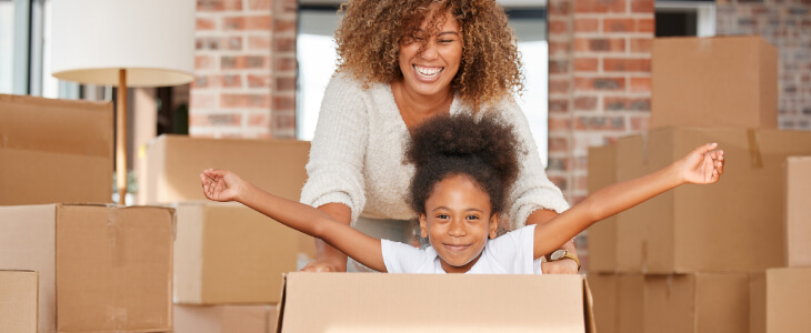 Mother pushing young daughter in a moving box