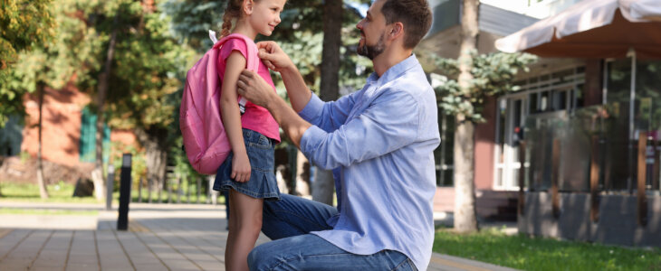 Father fixing daughter's outfit as she goes to school