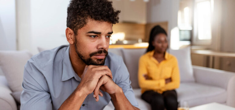 Close up of black african couple sitting together not looking at each other on couch