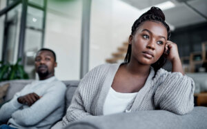 Shot of a young couple ignoring each other after having an argument on the sofa at home