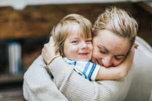 Happy mother embracing her small son at home