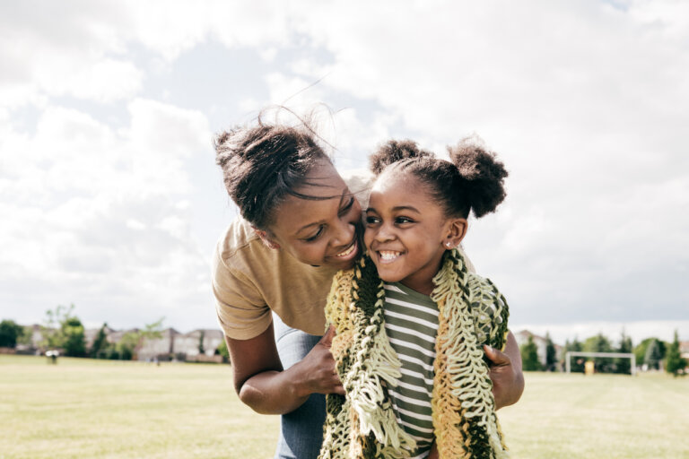 Supportive mom and little daughter outside on a sunny day