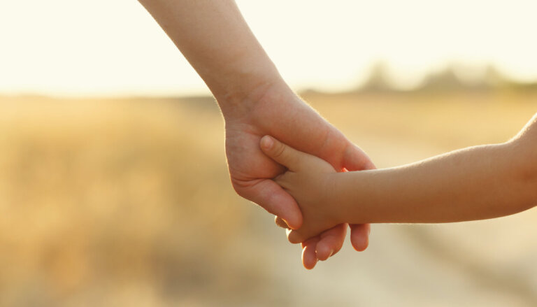 Father holds daughter by the hand.