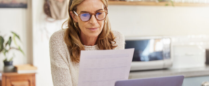 Budget, finance and retirement woman with laptop and paperwork for pension savings, bills or income investment on digital bank app. Elderly person with mortgage, financial document or tax management